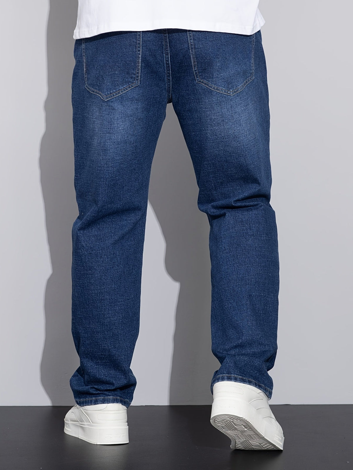 Men's mid-rise straight-leg stretch jeans in blue and black denim, detail view