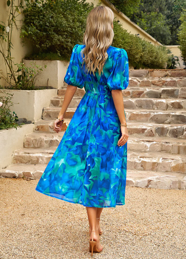 Women's floral print midi dress with a smocked waist and flowing skirt in bright multicolour shades